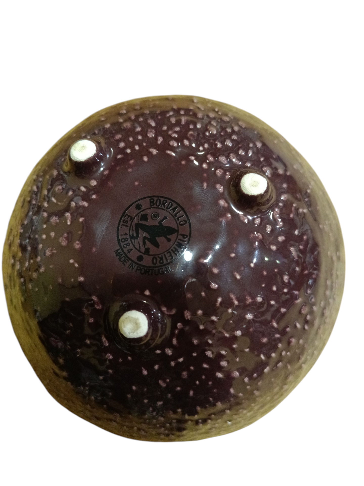 Taça de cerâmica castanha e roxa com base trípode e estampagem da marca.