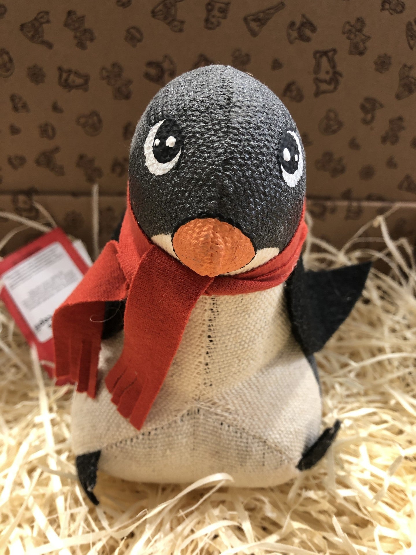 Pelúcia de pinguim com cachecol vermelho