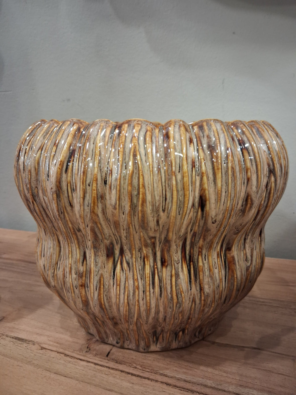 Vaso de cerâmica com textura ondulada e acabamento brilhante em tons castanho e creme