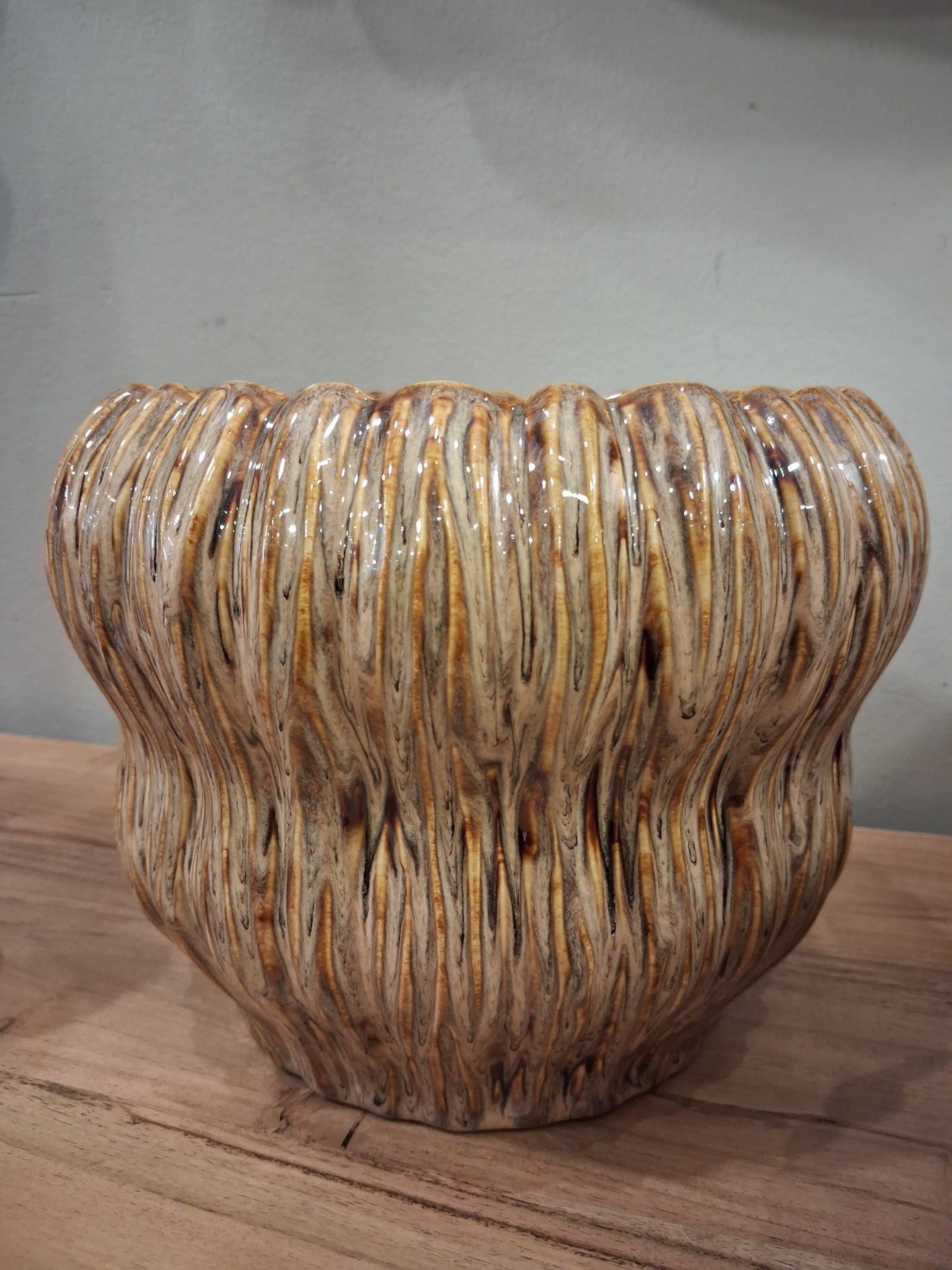 Vaso de cerâmica com textura ondulada e acabamento brilhante em tons castanho e creme