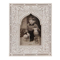 Fotografia antiga de rapaz num quadro decorativo branco com padrão floral