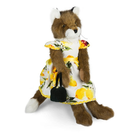 Pelúcia raposa com vestido floral amarelo e mala preta