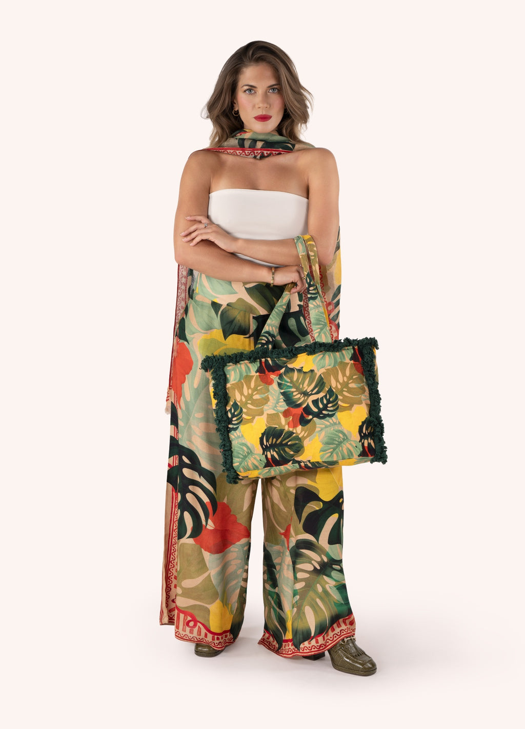 Mulher com roupa e mala estampadas com folhagem colorida