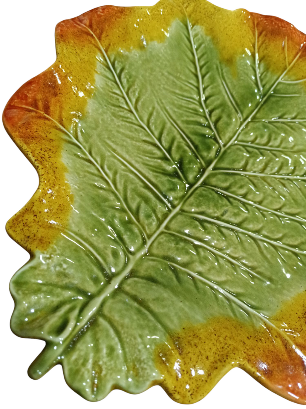 Prato cerâmico em forma de folha com cores verde, amarelo e laranja.