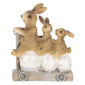 Escultura de coelhos e ovos num carrinho decorativo