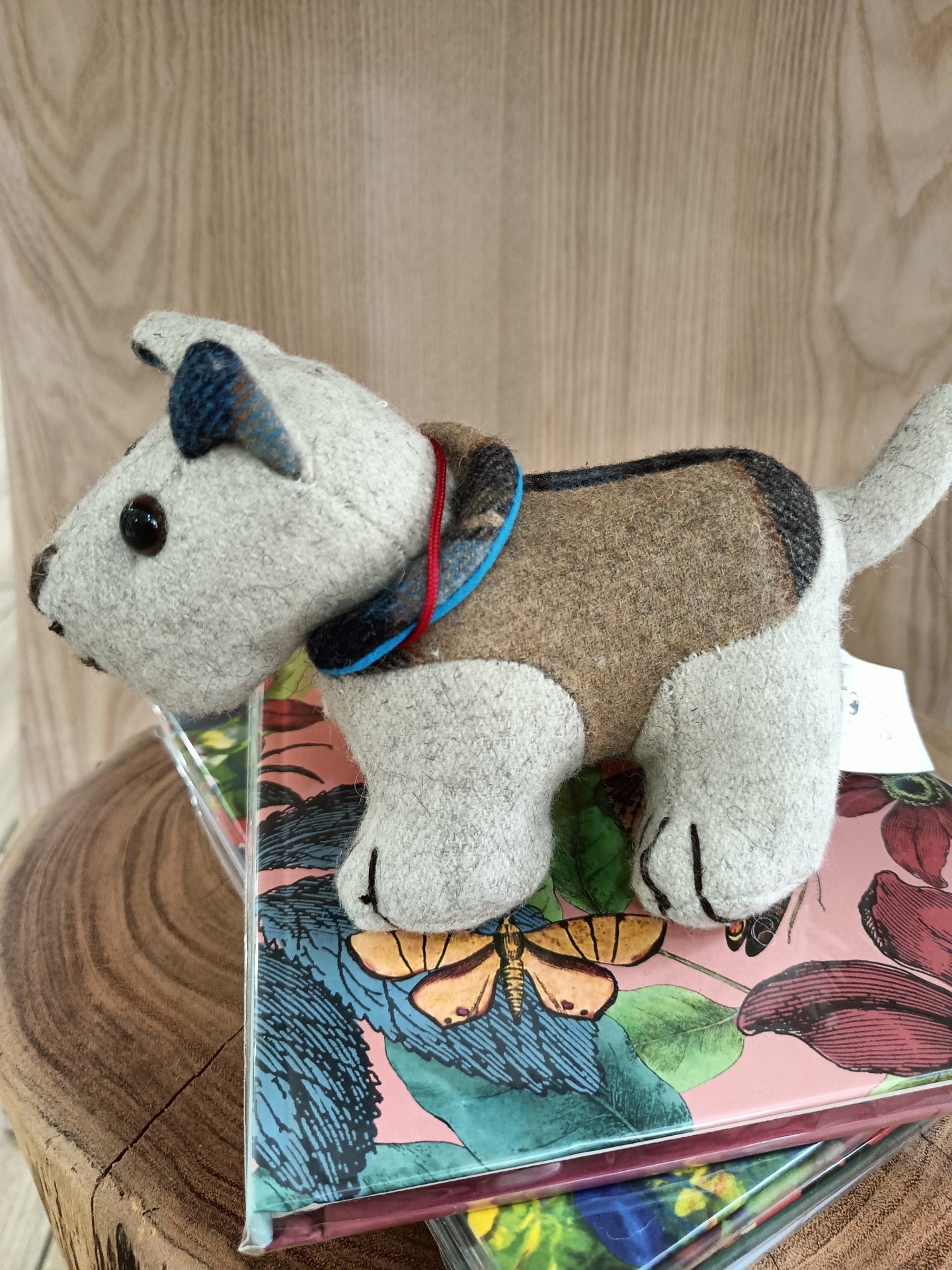 Brinquedo peluche de cão castanho e creme sobre capas florais coloridas