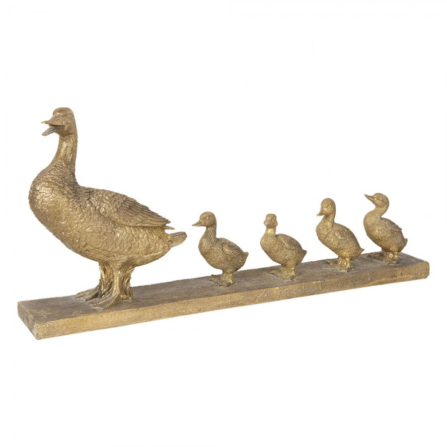 Escultura dourada de pato com quatro patinhos alinhados numa base