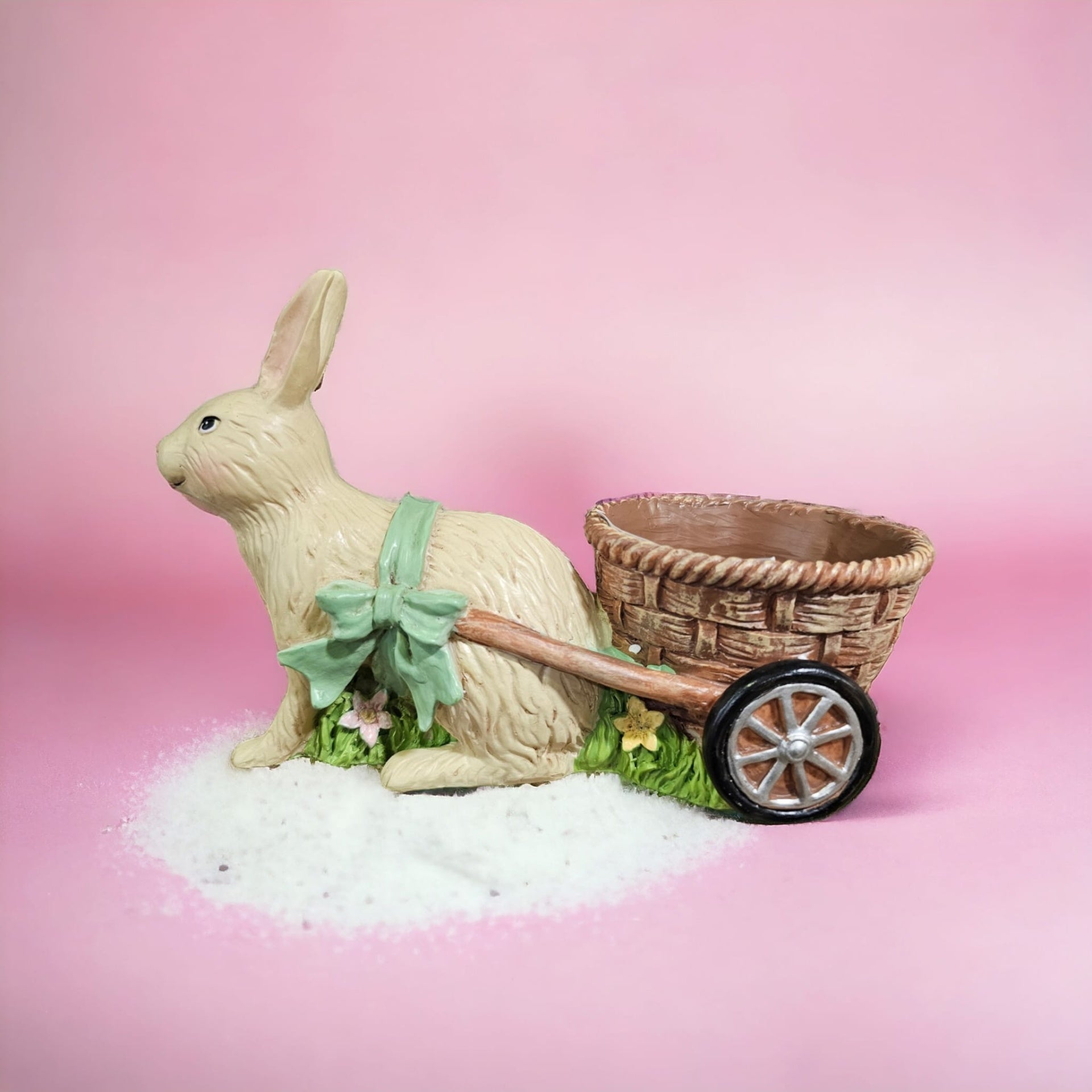 Figura decorativa de coelho com carrinho de cesto e laço verde
