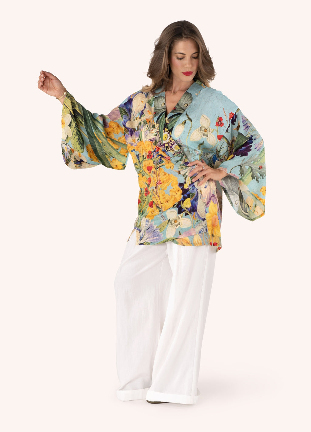 Blusa floral colorida de mangas largas com calças brancas largas