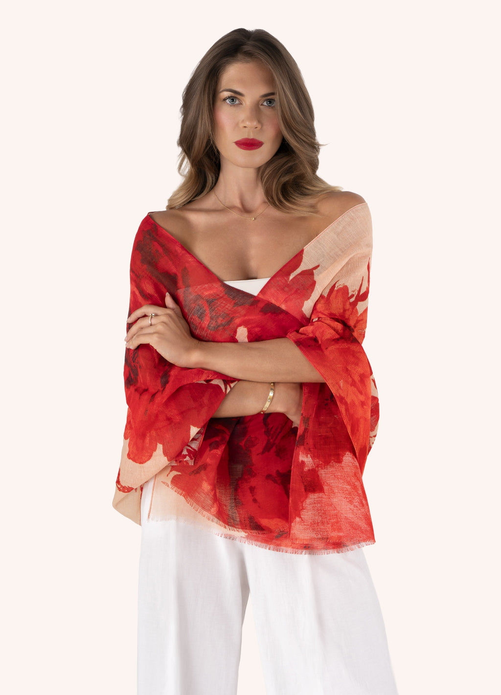 Mulher com echarpe vermelha floral e calças brancas