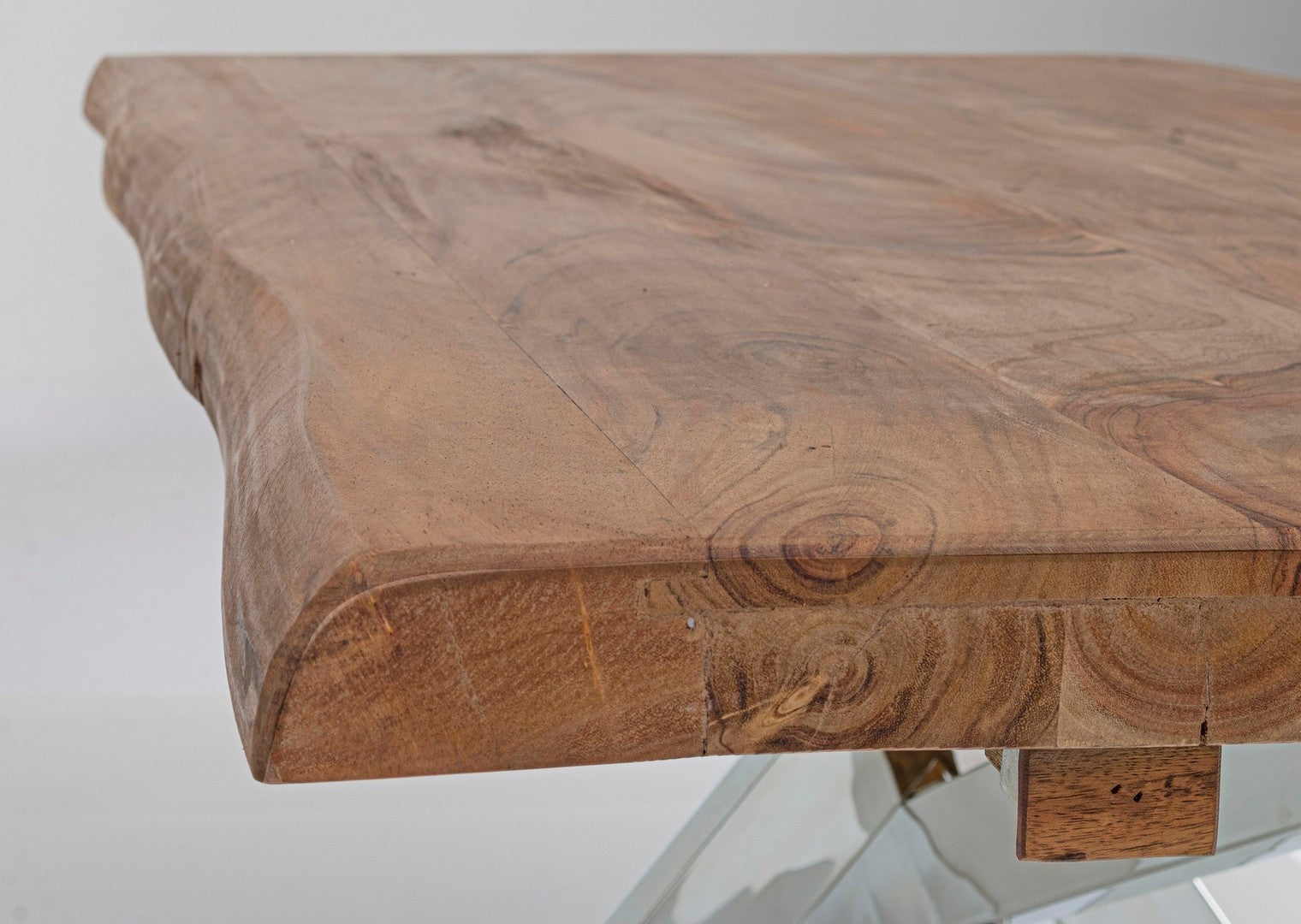Mesa de madeira com tampo natural e base transparente.