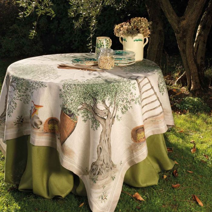 Mesa redonda com toalha decorativa com árvore e cestos em jardim sob árvore
