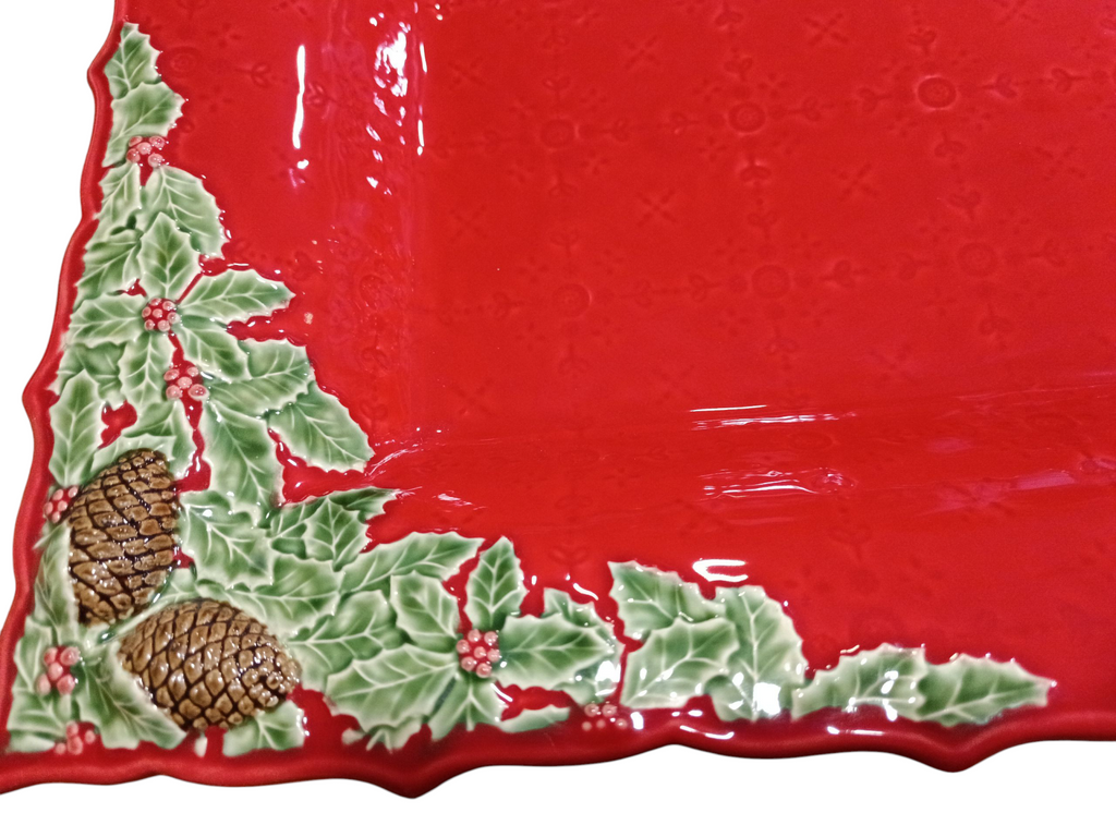 Prato cerâmico vermelho com decoração de azevinho, bagas e pinhas