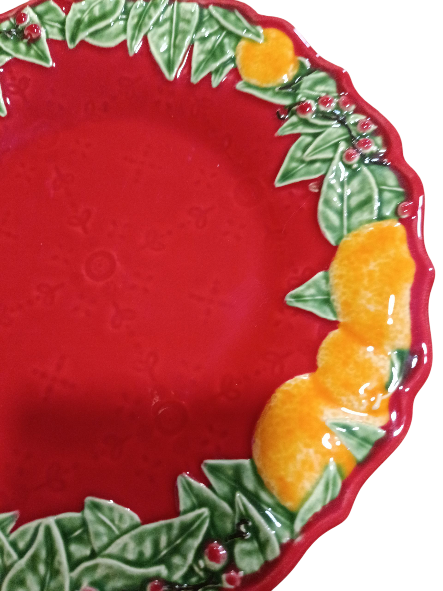 Prato decorativo vermelho com bordas decoradas com folhagens, bagas vermelhas e laranjas em cerâmica.