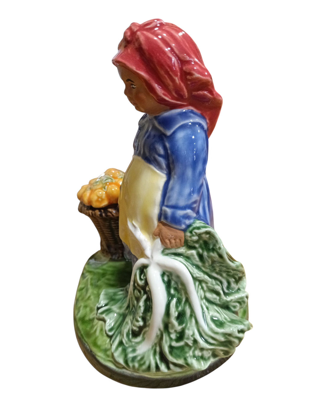 Figura cerâmica menina com lenço vermelho, vestido azul e avental branco segurando couve e cesto com abóboras