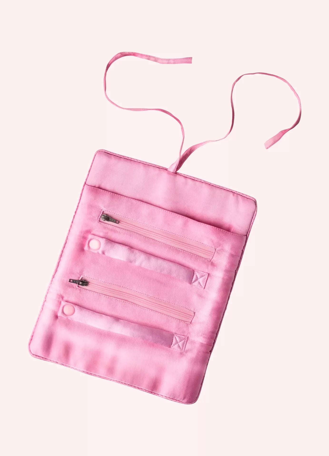Organizador rosa de tecido com três bolsos e tiras para pendurar