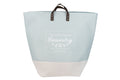 Saco de roupa suja azul claro com base bege, alças castanhas e texto branco
