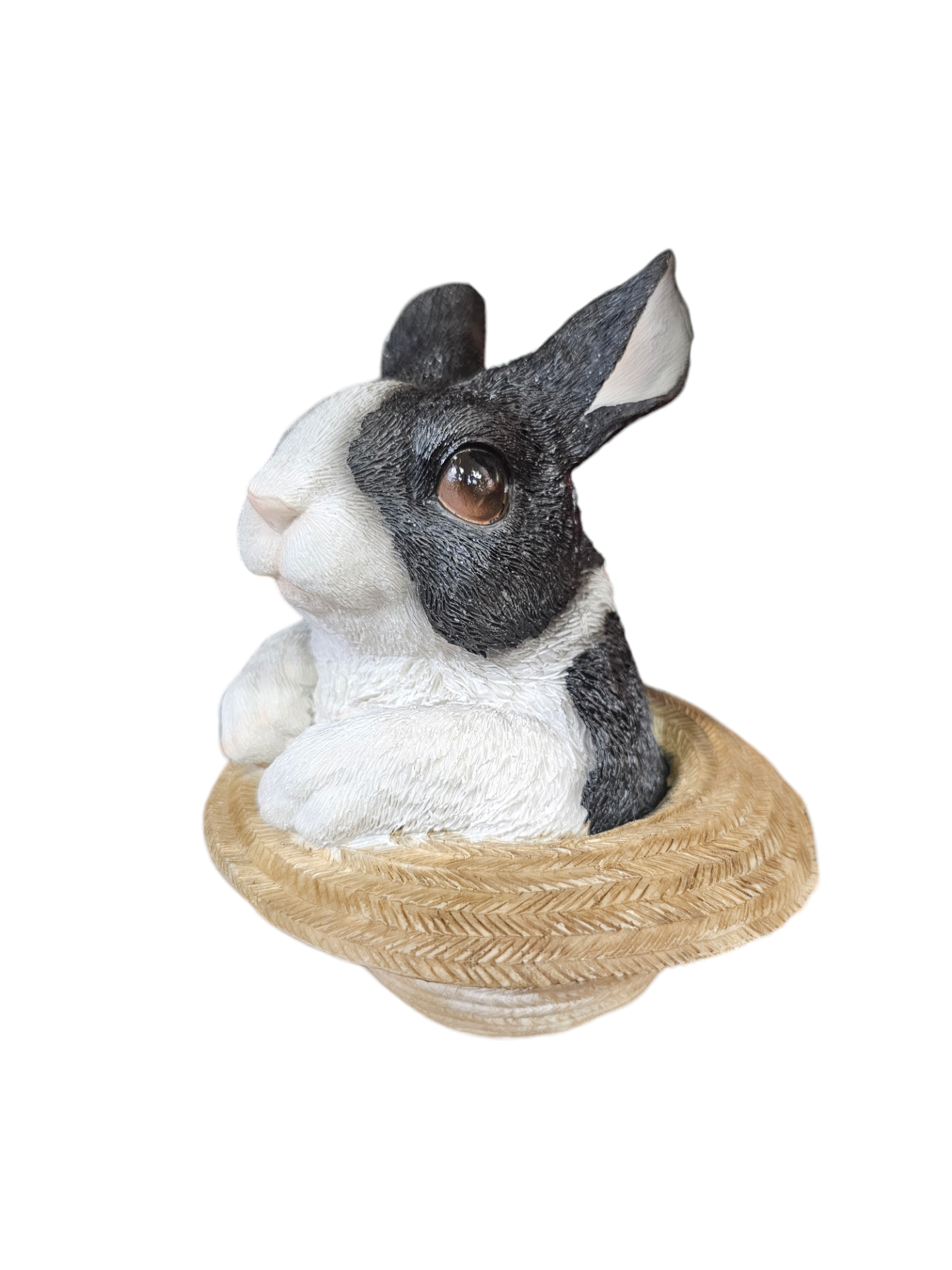 Escultura de coelho preto e branco numa base que parece chapéu de palha