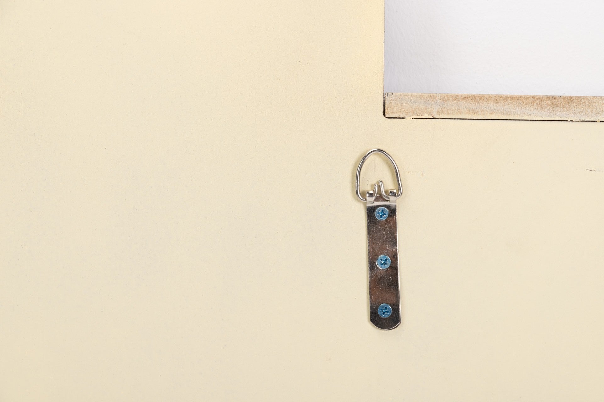Parte traseira de um quadro com suporte metálico e fita castanha para pendurar