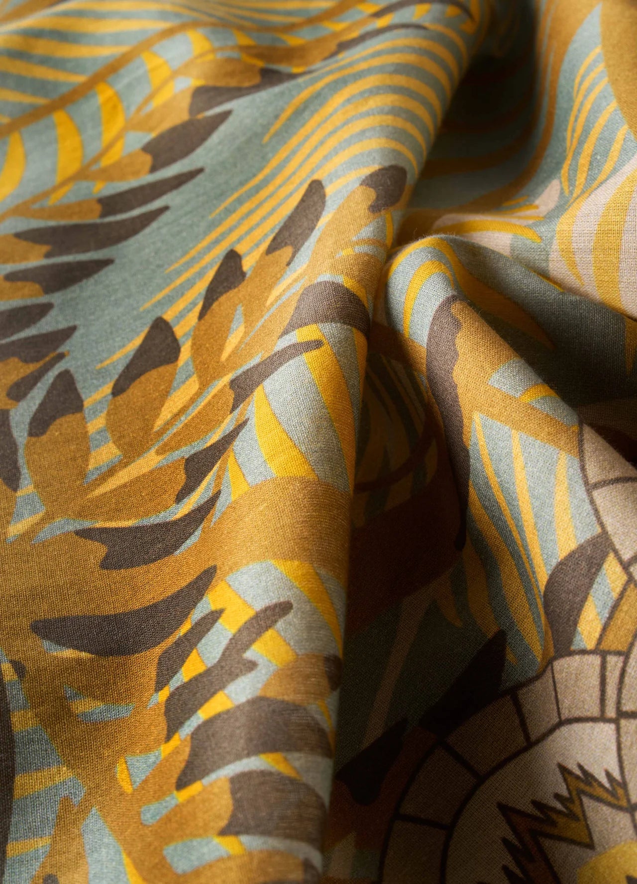 Tecido dobrado com padrão estampado em castanho, amarelo e azul claro