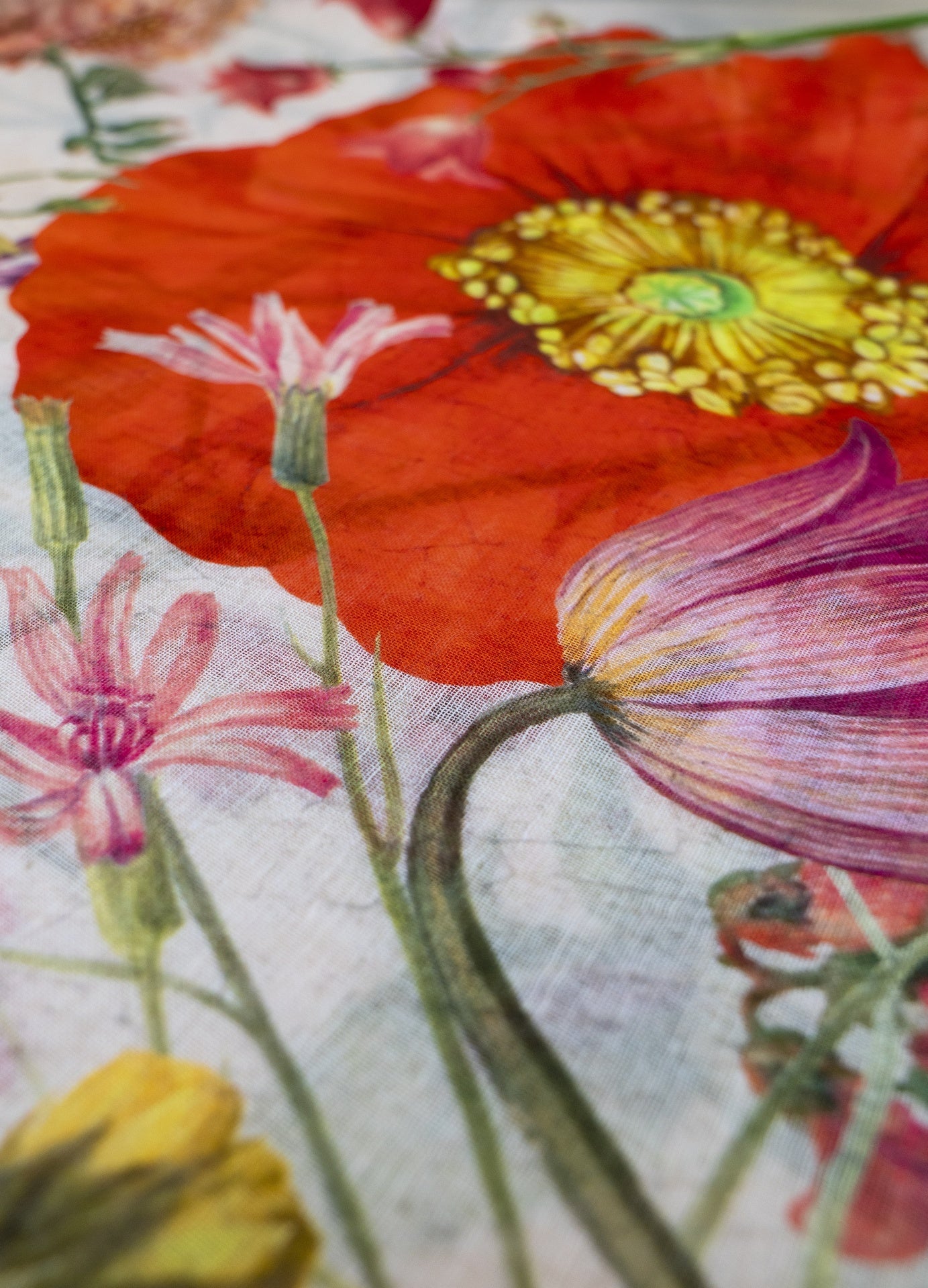Pano com padrão floral colorido em tecido com fundo branco e diversas flores grandes e coloridas.