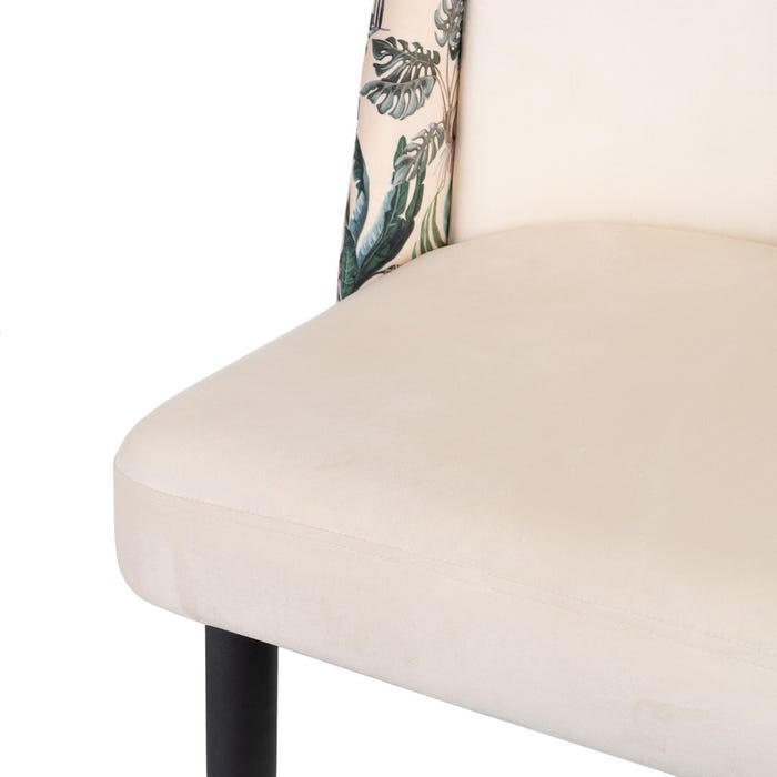 Detalhe de cadeira com assento creme e encosto com padrão de folhas verdes