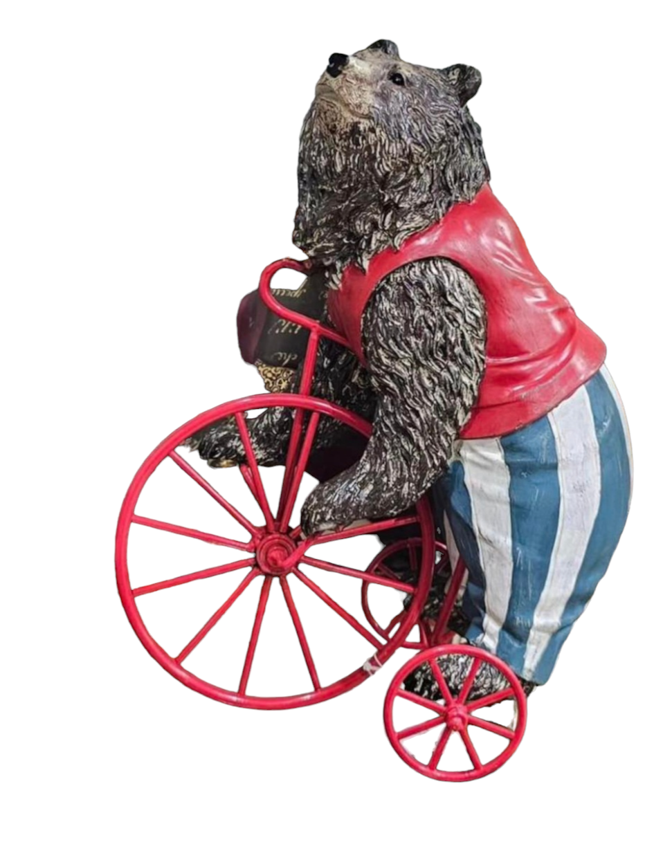 Estátua de urso com vestuário colorido e rodas vermelhas.