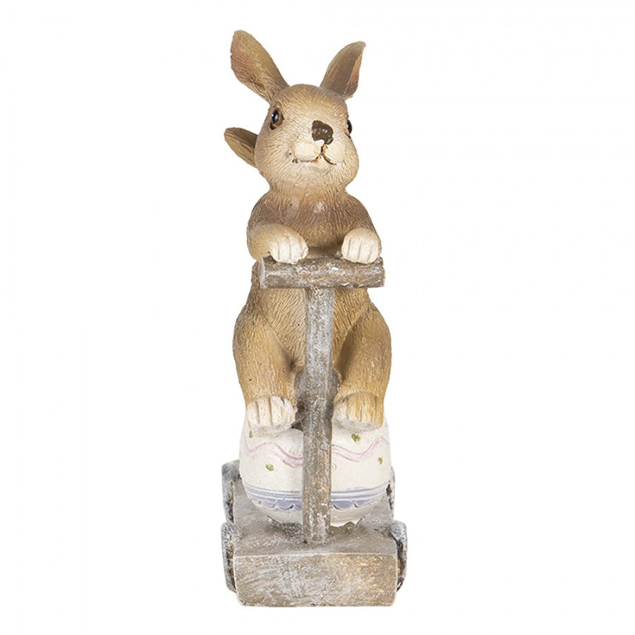 Figura decorativa de coelho com carrinho e ovo em fundo branco