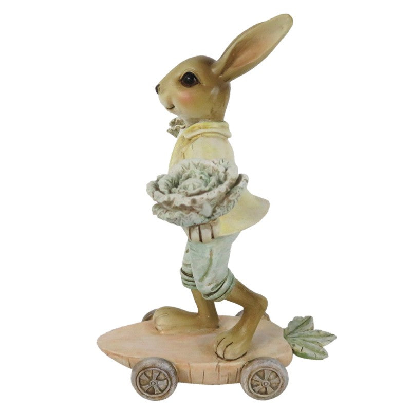 Figura decorativa de coelho com ninho segurado em skate de madeira.