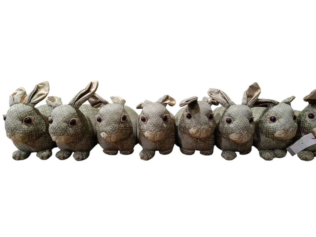 Oito peluches de coelhos feitos com tecido castanho e bege alinhados