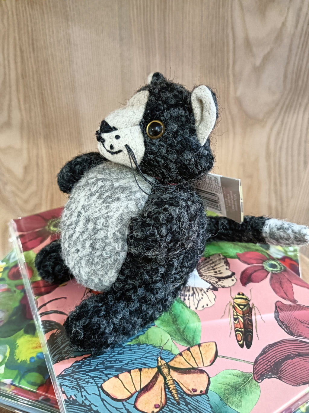 Pelúcia de gato preto e cinzento com livros coloridos