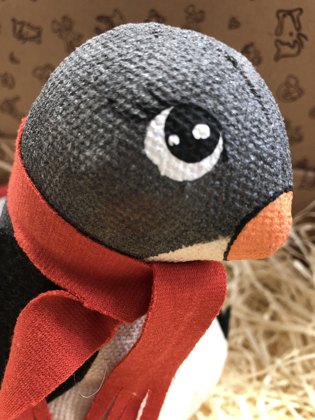 Pinguim de peluche com cachecol vermelho