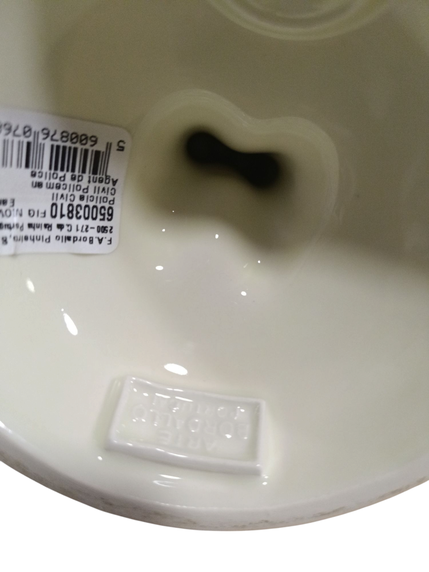 Interior de vaso cerâmico branco com etiqueta e selo em relevo