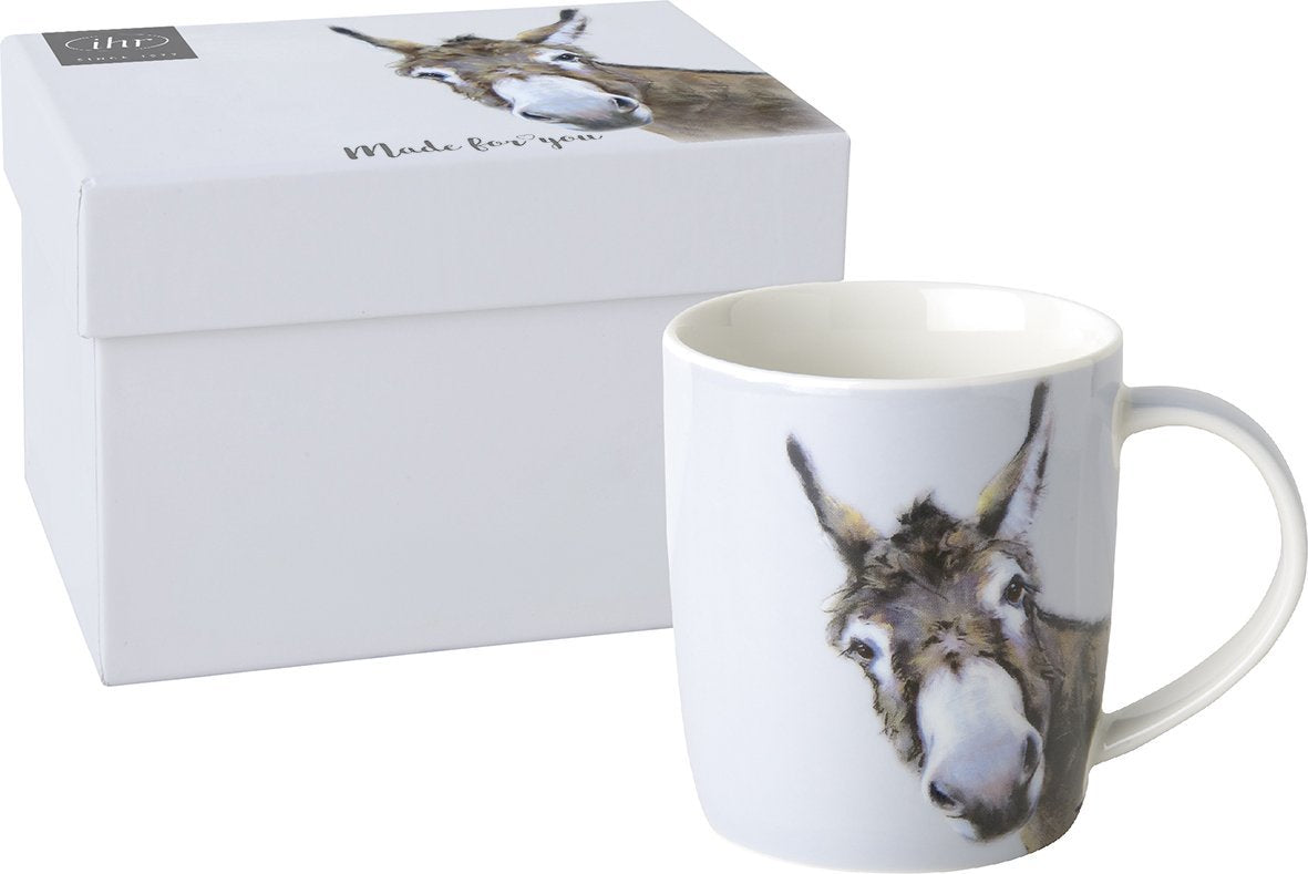 Caneca branca com cabeça de burro desenhada e caixa de presente