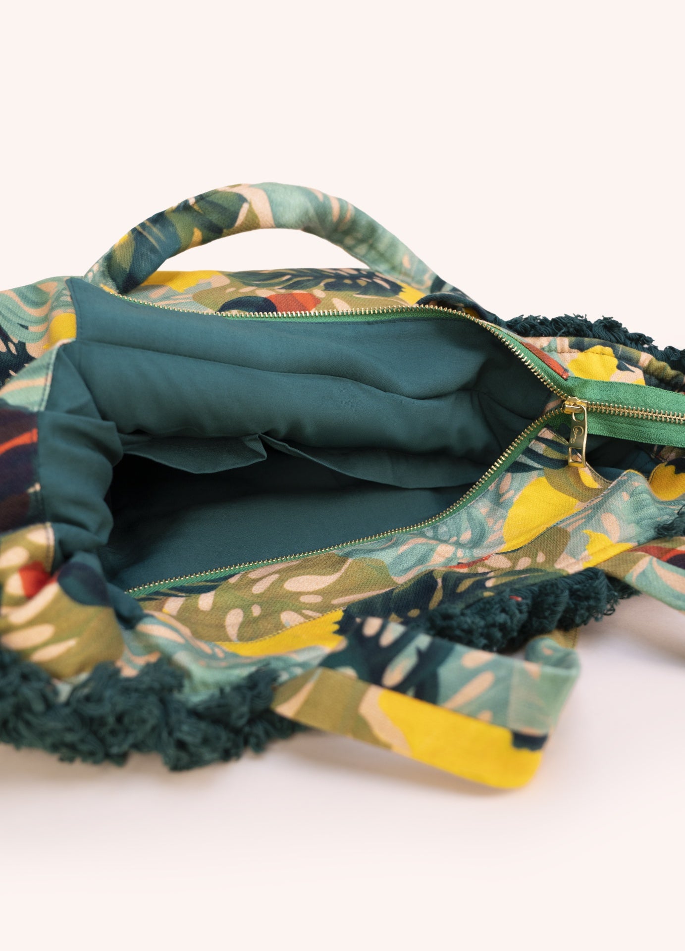 Mala estampada floral com interior verde e fecho dourado aberto