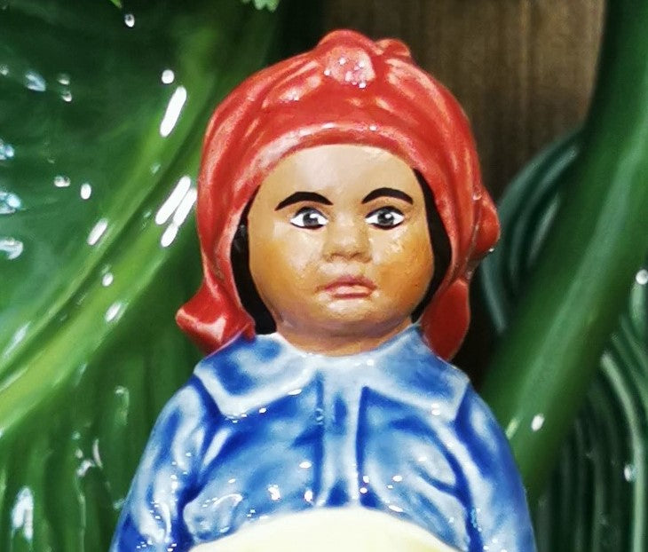 Figura decorativa em cerâmica de pessoa com lenço vermelho e camisa azul