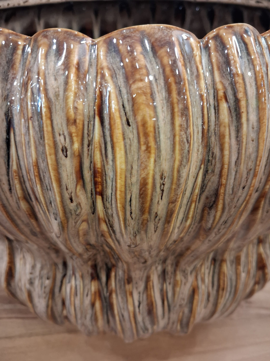Pormenor de vaso cerâmico ondulado em tons castanhos