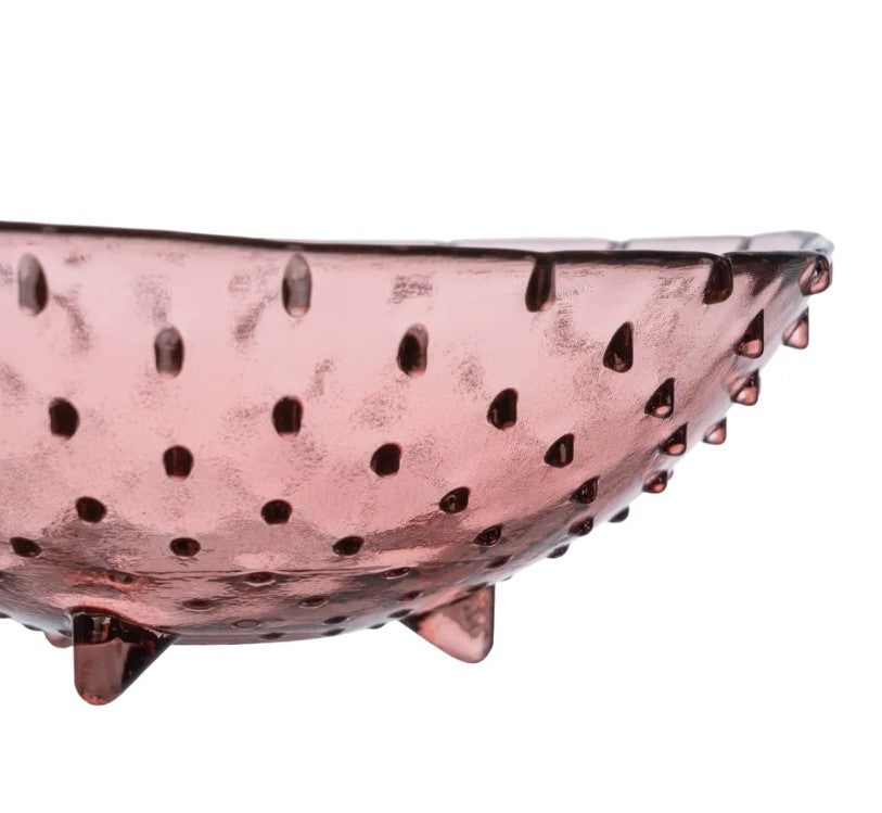 Taça ou prato raso em vidro rosa translúcido com textura pontilhada em relevo.