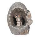 Escultura decorativa de coelhos em ovo partido cinzento com flores na base