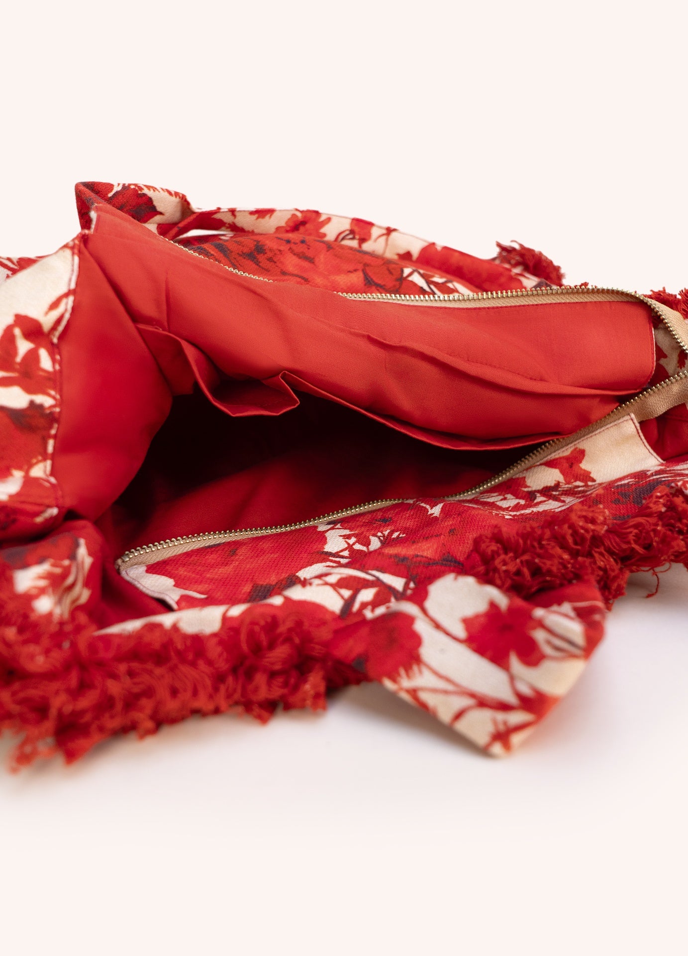 Saco de tecido vermelho com padrão floral e interior vermelho com fecho