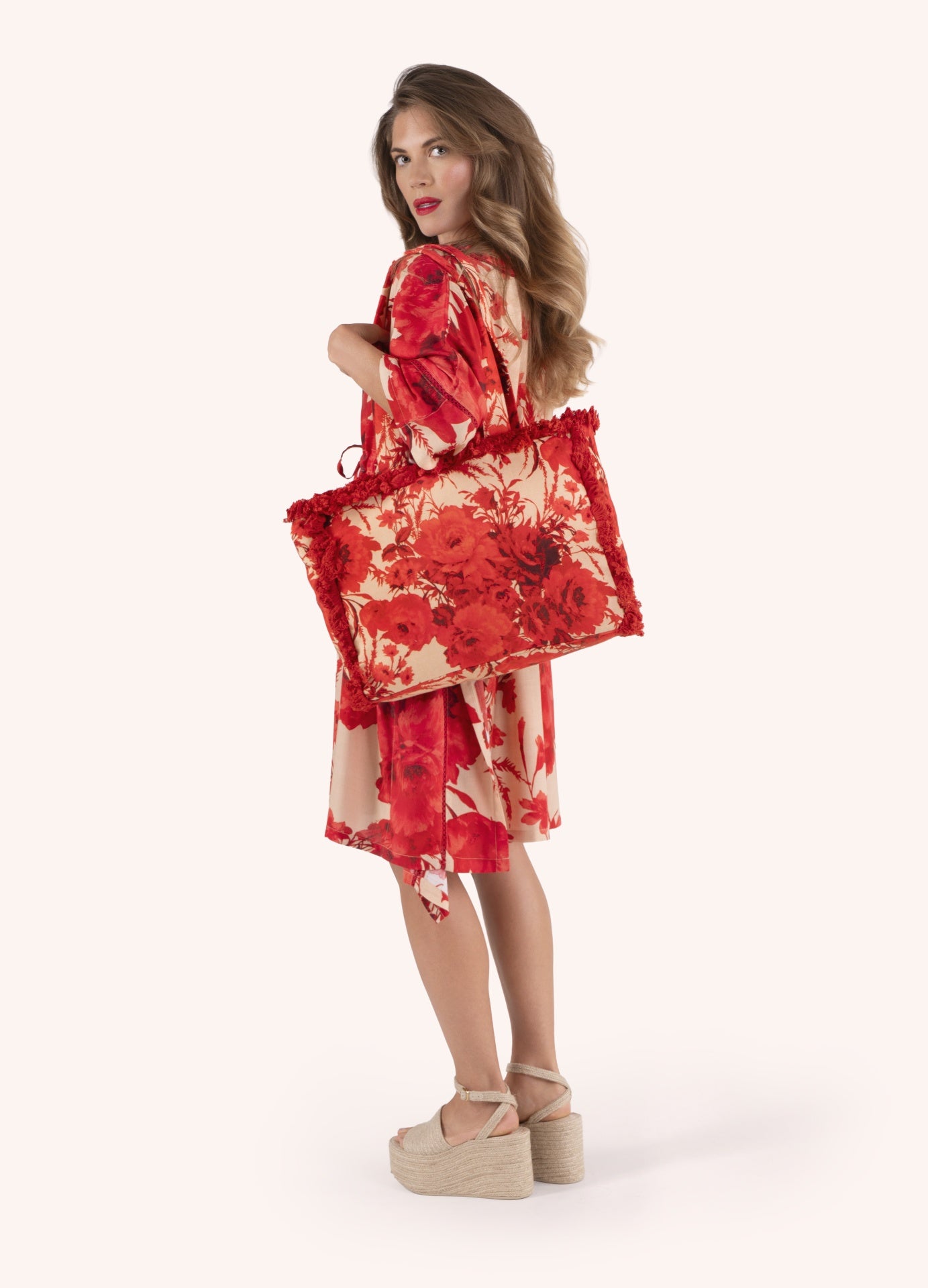 Mulher a usar vestido e bolsa com padrão floral vermelho
