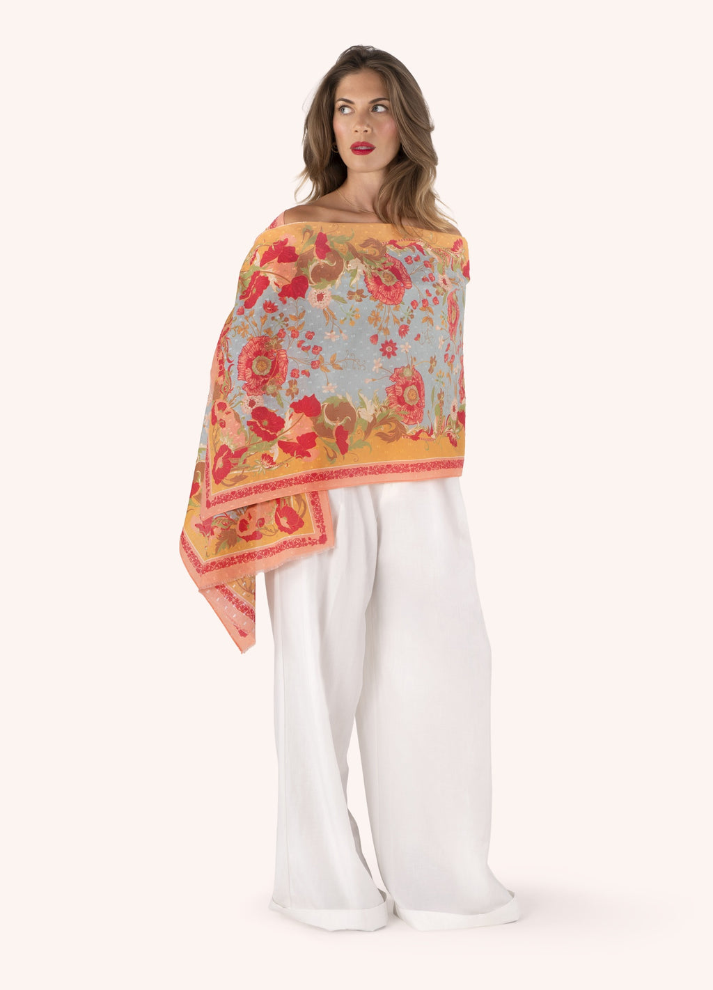 Modelo com lenço floral colorido e calças brancas largas
