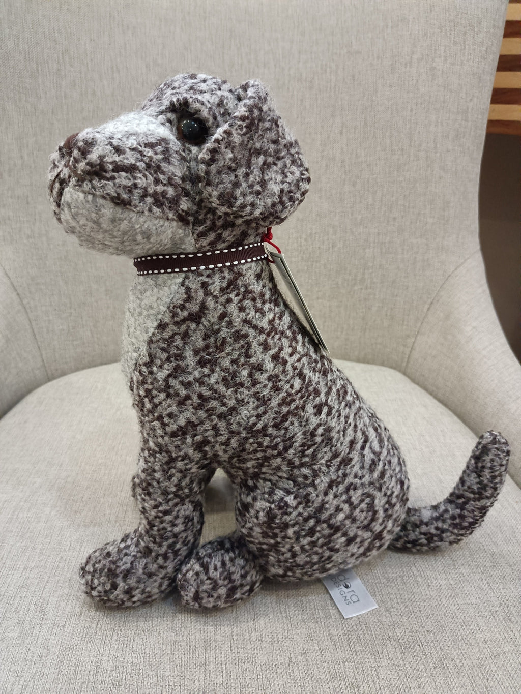 Pelúcia de cachorro cinzento e branco numa cadeira cinzenta
