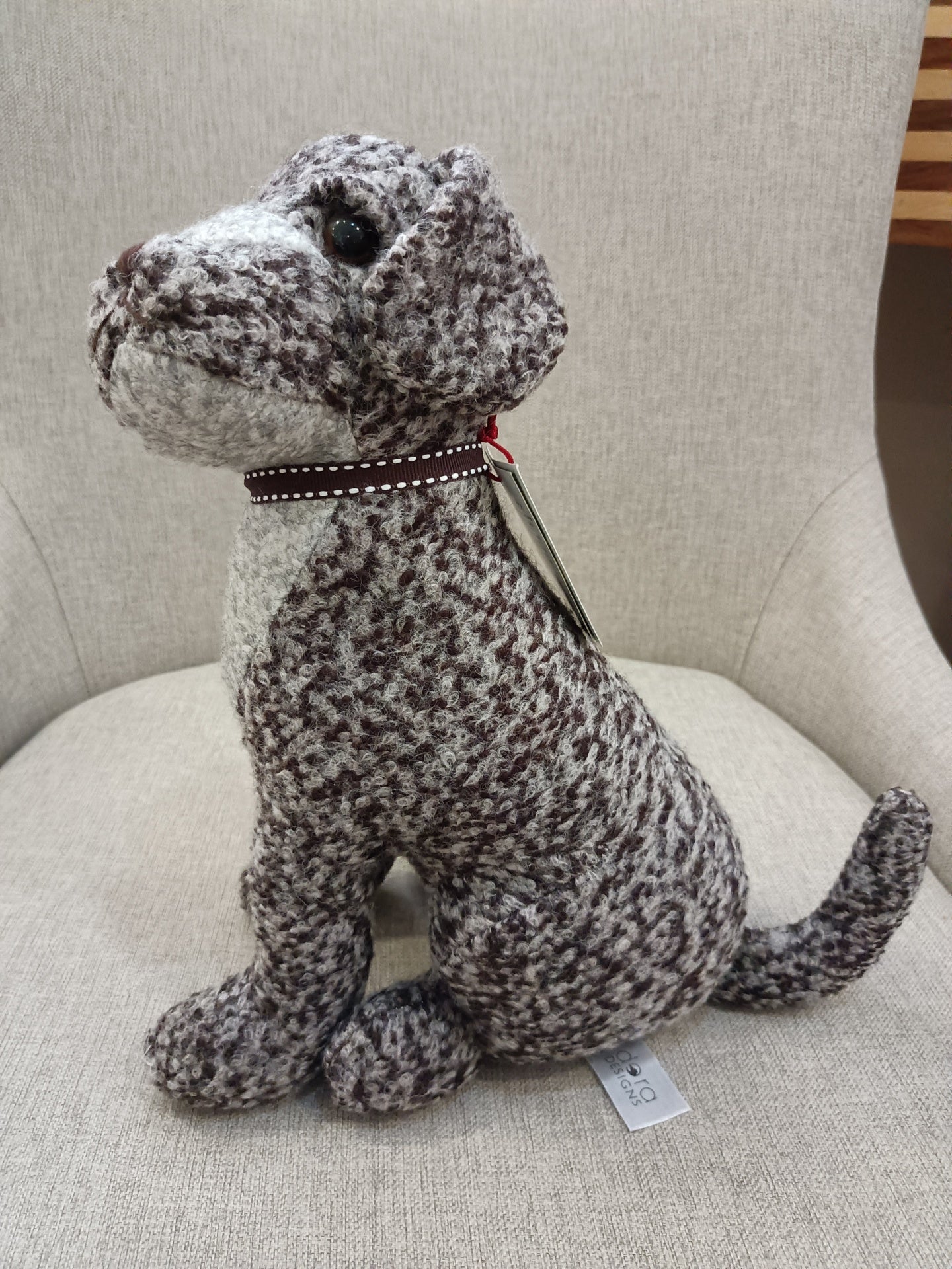 Pelúcia de cachorro cinzento e branco numa cadeira cinzenta
