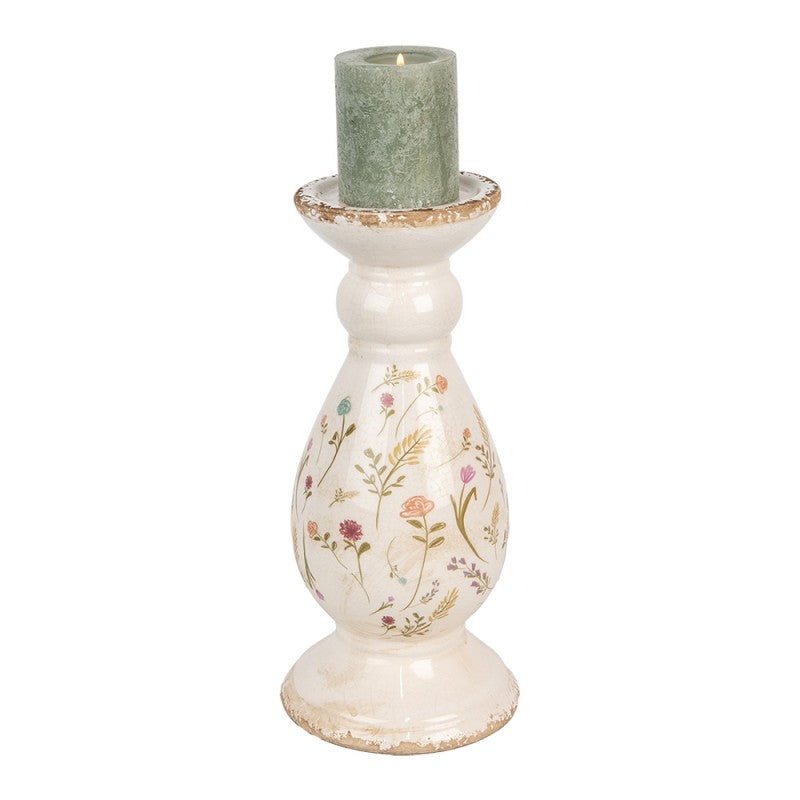 Castiçal de cerâmica branco com padrão floral e vela verde no topo