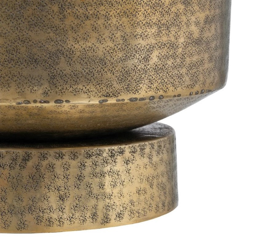Objeto decorativo metálico dourado envelhecido com textura pontilhada.