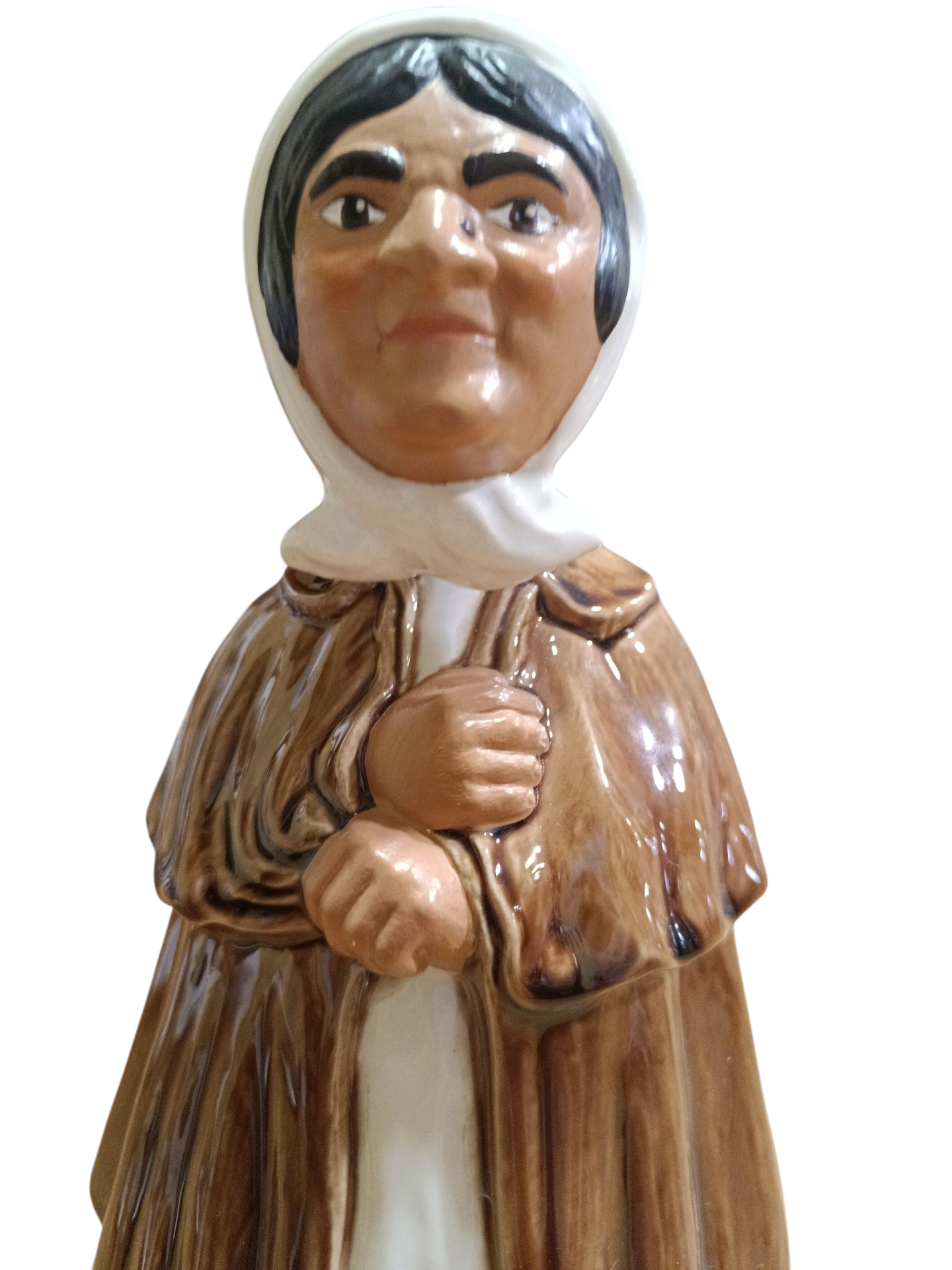 Figura de cerâmica de mulher com lenço branco, vestido e xale castanho.