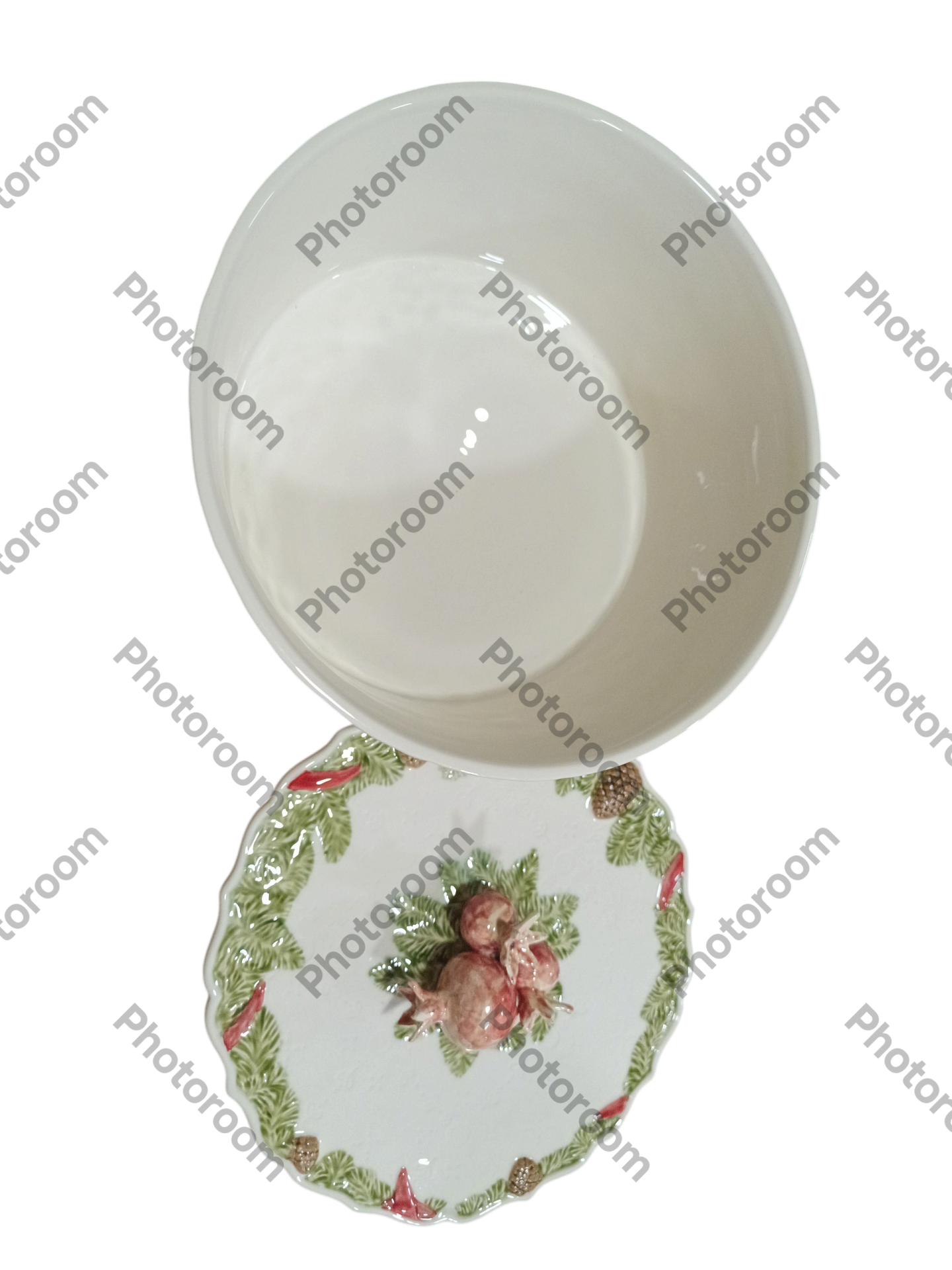 Taça de cerâmica branca sobre prato decorativo com folhas verdes e frutos vermelhos.