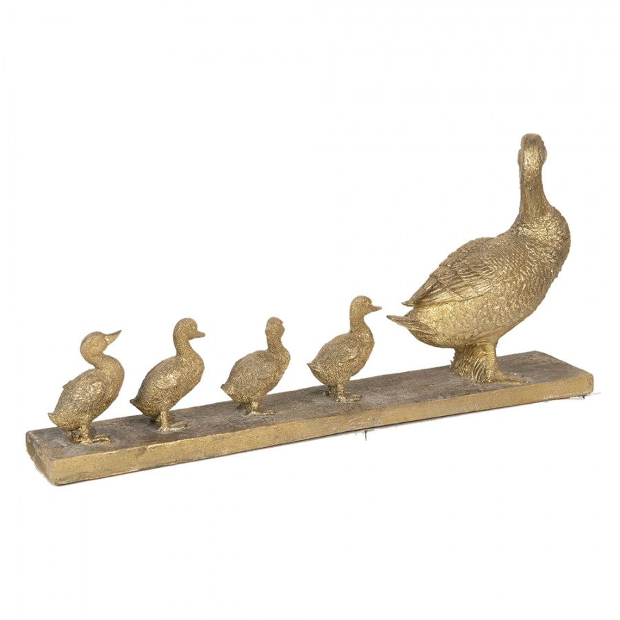Escultura dourada de pato com quatro patinhos numa base retangular