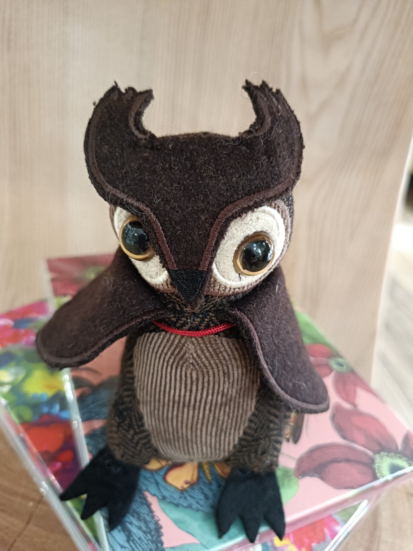 Boneco de coruja de tecido castanho com olhos grandes e peito riscado